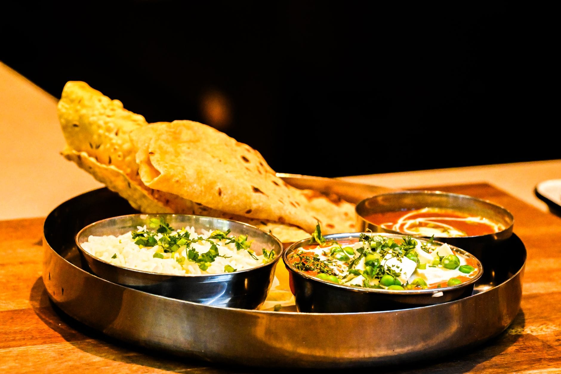 Indyjskie thali z naanem, curry z paneerem i ryżem na stole